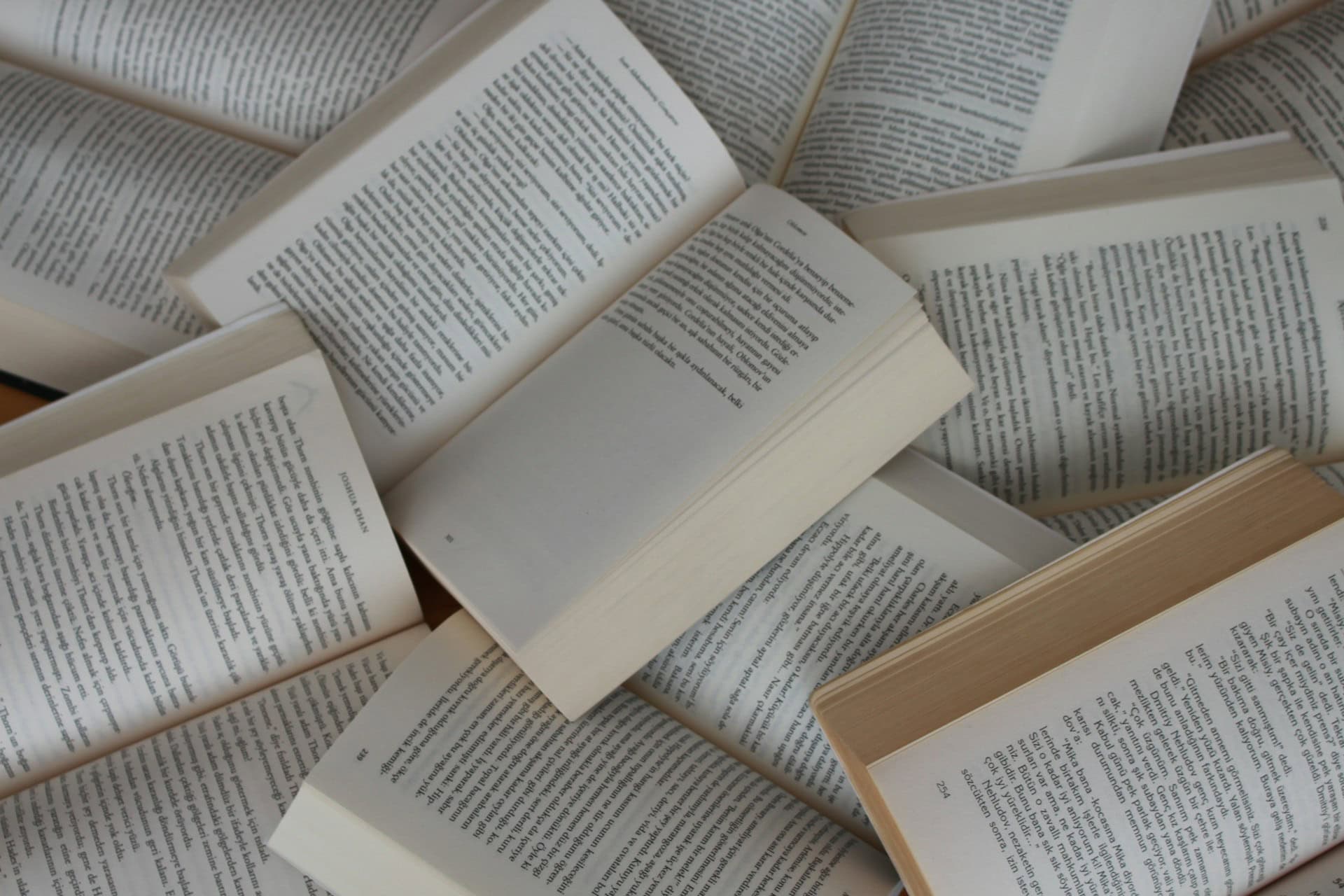 A collection of open books displaying their text.